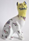 Wemyss ware, a white cat with yellow head, decorated with pink and purple flowers and blue features,