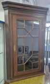 A 19th century mahogany corner cabinet, with geometric glass door, gilt lockplate and hinges, with