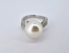 A diamond and pearl ring, set in 18ct white gold, marked on inside band 'Spires, DO.47', diameter