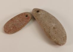 Two Stone Axe Heads with pierced holes for the attaching of twine. Length of longest: 10.2cm