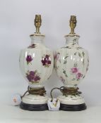 Two floral design lamps on cream ground both depicting roses, both on wooden plinths, tallest 40cm
