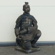 Terracotta style garden ornament of a kneeling Chinese warrior on a square base. (Head and hand