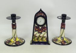 Moorcroft Pansy design on dark blue ground set of three to include two candle sticks and a centre