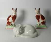 A pair of reproduction Staffordshire seated cat figures, together with a Just Cats & Co figure,