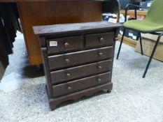 Miniature chest of stained pine 2 over 3 drawers, one leg damaged, H 55cm, W 52.5cm, D 20cm.