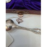 A cased set of 12 Sterling silver teaspoons with embossed scroll bordered handles. Cased napkin ring