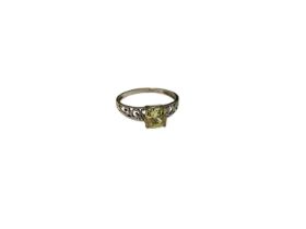 Single stone ring with a cushion cut fancy yellow stone in 9ct white gold open work scroll setting,
