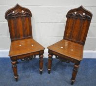 A PAIR OF 20TH CENTURY OAK GOTHIC STYLE HALL CHAIRS, the shaped backrest with quatrefoil details,