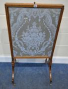 A REGENCY WALNUT FIRE SCREEN, with two sliding screens, and a rise and fall screen, raised on shaped