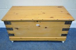 A 20TH CENTURY PINE LIDDED CHEST, with twin metal handles, raised on later castors, width 84cm x