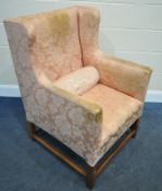 A LARGE GEORGIAN WING BACK ARMCHAIR, with pink floral upholstery, raised on a fruitwood frame, width
