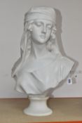 A WHITE COMPOSITE BUST OF A FEMALE WITH A HEADSCARF on a circular pedestal plinth, height 55cm x