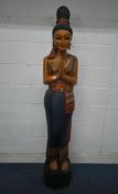 A THAI CARVED AND PAINTED WOODEN FIGURE OF A SAWASDEE FEMALE, with coloured mirror details, raised