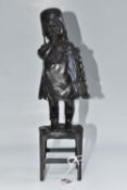 IN THE STYLE OF JUAN CLARA, A BRONZE FIGURE OF A GIRL, standing on a stool, black finish, height