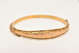 A 9CT GOLD HINGED BANGLE, a tapered floral bangle with beading detail, fitted with an integrated