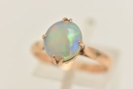 A YELLOW METAL AND SINGLE OPAL RING, oval opal double prong set in yellow metal, pinched