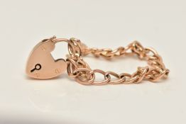 A YELLOW METAL CURB LINK BRACELET, fitted with a heart padlock clasp, stamped 9ct, approximate gross