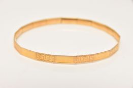 A 9CT GOLD BANGLE, panel design yellow gold bangle with interspaced polished and Greek key detail,