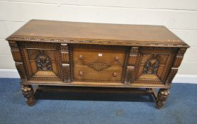 A 20TH CENTURY OAK SIDEBOARD, fitted with two drawers, flanked by two cupboard doors, raised on