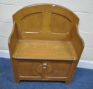 A 20TH CENTURY OAK SETTLE, of small proportions, with an arched back, and a hinged seat, width