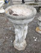 A COMPOSITE BIRD BATH IN THE FORM OF THREE SCANTILY CLAD LADIES, holding aloft a bowl, height