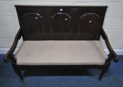 A GEORGIAN OAK SETTLE, with three panels to the back rest, scrolled open armrests, width 140cm x