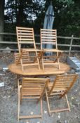 A WOODEN OVAL FOLDING GARDEN TABLE, length 150cm x depth 90cm x height 74cm, a set of six matching