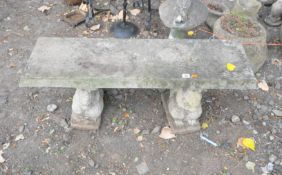 A RECTANGULAR COMPOSITE GARDEN BENCH, raised on twin pedestals in the form of squirrels, width 104cm