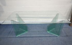 A GLASS TABLE, raised on twin shaped pedestals, length 179cm x depth 70cm x height 74cm, condition