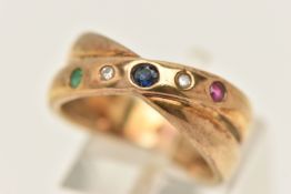 A 9CT GOLD GEM SET CROSS OVER RING, set with ruby, sapphire, emerald and diamond circular stones