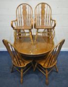 A LATE 20TH CENTURY OAK EXTENDING DINING TABLE, raised on a single pedestal, four legs with ball and
