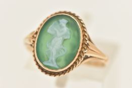 A YELLOW METAL GREEN AGATE CAMEO RING, oval cameo collet set within a rope twist surround,