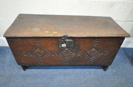 A 17TH CENTURY OAK SIX PLANK CHEST, the front with carved geometric patterns, raised on shaped legs,