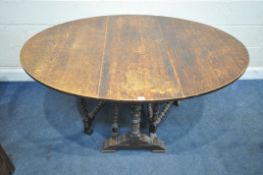 AN EARLY 20TH CENTURY OAK GATE LEG TABLE, raised on turned supports, united by stretchers, open