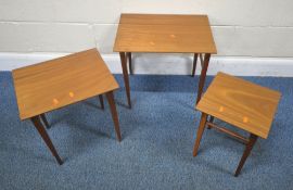 A MID-CENTURY TEAK NEST OF THREE TABLES, raised on square tapered legs, largest table width 51cm x