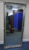 A LARGE SILVERED BEVELLED EDGE WALL MIRROR, with foliate details, 168cm x 77cm, condition report: