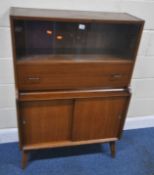 A MID-CENTURY TEAK COCKTAIL CABINET, with double glass sliding doors, a fall front drawer, and