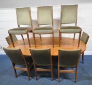 G PLAN, A MID-CENTURY TEAK EXTENDING DINING TABLE, with a single fold out leaf, raised on shaped