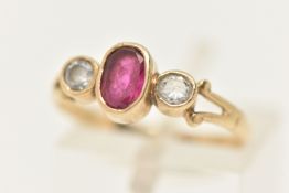 A 9CT GOLD RUBY AND CUBIC ZIRCONIA RING, collet set with an oval cut ruby, flanked with two collet