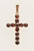 A YELLOW METAL GARNET SET CROSS PENDANT, set with circular cut garnets, fitted with a tapered