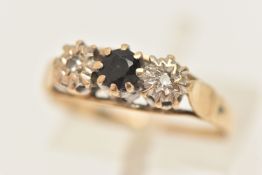 A 9CT GOLD SAPPHIRE AND DIAMOND RING, set with a central circular cut deep blue sapphire, flanked