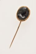 A CASED YELLOW METAL HIGH RELIEF JET CAMEO STICK PIN, of an oval form, depicting a lady in