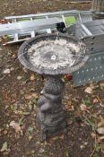 A CONCRETE BIRD BATH in the form of a cherub holding a man urn with bowl atop, Condition Report: