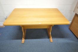 A MODERN LIGHT OAK RECTANGULAR DINING TABLE, raised on trestle style legs, united by a stretcher,