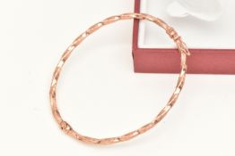 A BOXED ROSE METAL TWISTED BANGLE, hollow bangle fitted with a figure of eight safety clasp,
