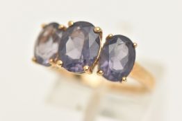 A 9CT GOLD AMETHYST SET RING, set with three oval cut amethysts, each in a four claw setting, to a