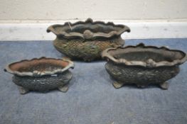 A SET OF THREE CAST IRON GRADUATED PLANTERS, with scrolled handles, foliate and geometric