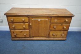 A 19TH CENTURY PINE SIDEBOARD, fitted with two banks of three drawers, flanking a single cupboard