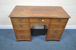 A GEORGIAN STYLE MAHOGANY KNEE HOLE DESK, fitted with an arrangement of nine drawers, an arched