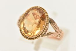 A YELLOW METAL CITRINE DRESS RING, set with an oval cut Citrine, claw set within a fine rope twist